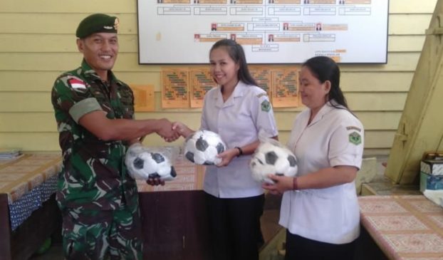 Satgas Pamtas Yonif Raider 303/SSM Kostrad menyerahkan bantuan sarana olaharaga kepada pihak Sekolah Dasar di Long Bagun